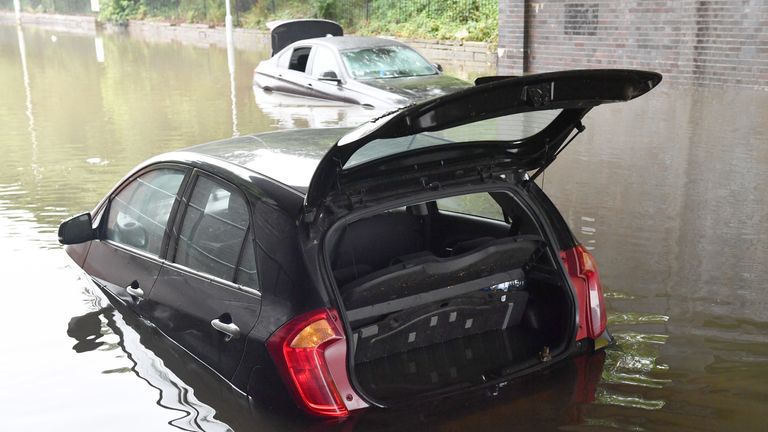 Cars are trapped in flood water on Crossley Road near Levenshulme