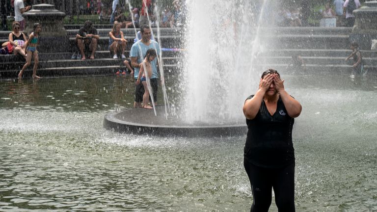 People cool off in Washington Square Park, New York, as temperatures begin to climb