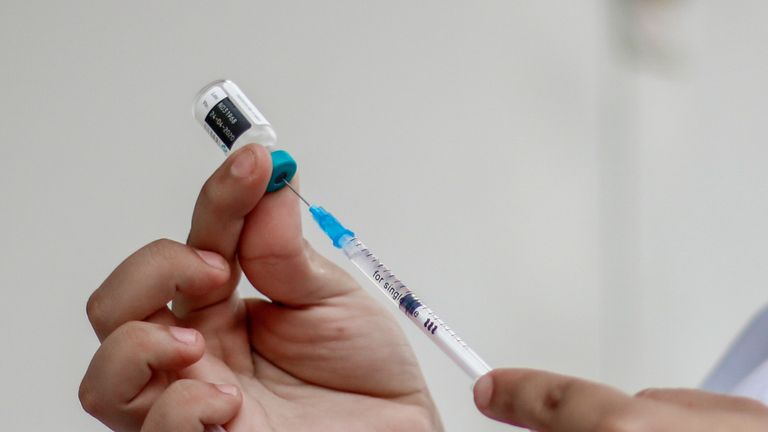 A medic preparing to inoculate using a vaccine