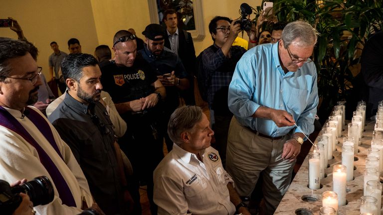 Texas Governor Greg Abbott (C) and El Paso Mayor Dee Margo (R) light candles after a vigil ceremony at Saint Pius X Church, following a deadly mass shooting, in El Paso, Texas, August 3, 2019. - A gunman armed with an assault rifle killed 20 people Saturday when he opened fire on shoppers at a packed Walmart store in Texas, the latest mass shooting in the United States. Texas authorities are investigating the Saturday mass shooting at a Walmart store in El Paso as a possible hate crime, the city's police chief said, as authorities study an online manifesto linked to the suspect. (Photo by Joel Angel JUAREZ / AFP)        (Photo credit should read JOEL ANGEL JUAREZ/AFP/Getty Images)