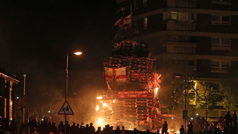 Crowds watch as a bonfire is lit in the New Lodge area of Belfast to mark the anniversary of the introduction of the controversial policy of internment without trial..