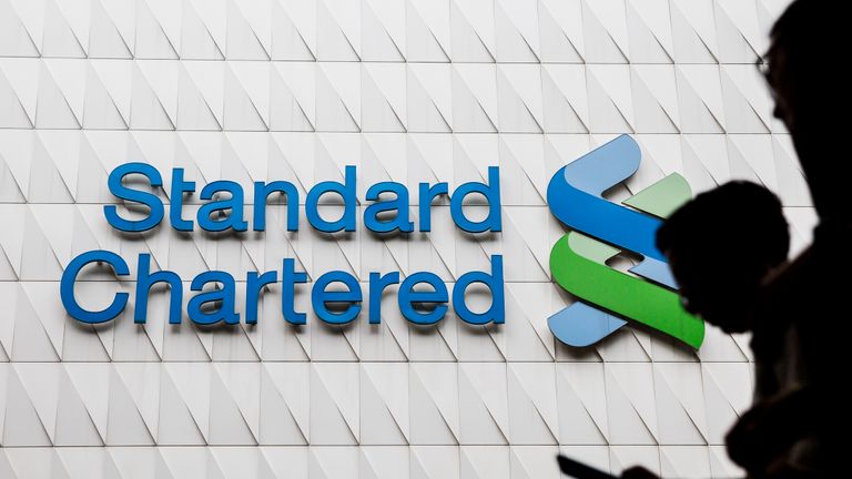 Pedestrians walk past Standard Chartered signage in the Central district of Hong Kong on August 2, 2017.
Standard Chartered's half-year results will be announced later in the day. / AFP PHOTO / Isaac LAWRENCE        (Photo credit should read ISAAC LAWRENCE/AFP/Getty Images)