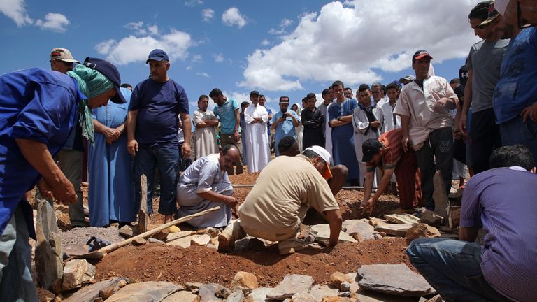 People dig a grave as they bury the victims of flooding when a river burst its banks and flooded a village football pitch where a game was being played, in Morocco's southern village of Tizert in the Taroudant region on August 29, 2019. - The victims included a 17-year-old boy and six elderly men attending the match in the village of Tizert, in Taroudant region. Searchers had rescued one man who was injured by the flood and were looking for another missing person, officials said. The river overflowed and submerged the pitch where an amateur football tournament was under way, a resident told AFP. (Photo by - / AFP)        (Photo credit should read -/AFP/Getty Images)