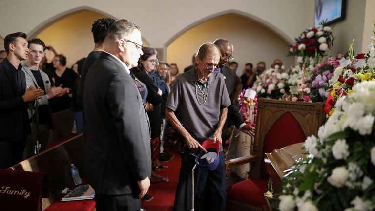 Antonio Basco, whose wife Margie Reckard was murdered during a shooting at a Walmart store, is comforted by a woman next to a white wooden cross bearing the name of his late wife, at a memorial for the victims of the shooting in El Paso, Texas, U.S. August 15, 2019. REUTERS/Jose Luis Gonzalez TPX IMAGES OF THE DAY