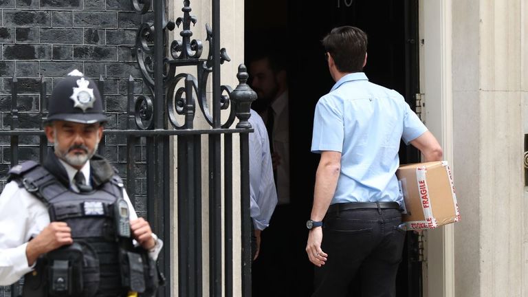 A package containing a digital countdown clock is carried in to 10 Downing Street in London.