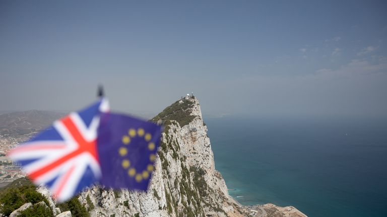 The Union Jack and the Flag of The European Union with The Rock of Gibraltar in the background, indicating the dispute over its sovereignty and the effects of Brexit with plenty of copyspace