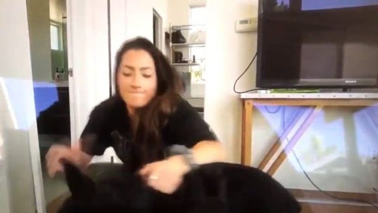 Brooke Houts aggressively pinned her dog to the floor before appearing to spit on him. Pic: YouTube/Brooke Houts