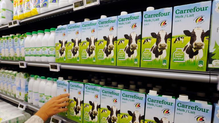 A customer takes a milk tetra pak from the dairy department of a Carrefour grocery store in Brussels September 4, 2014