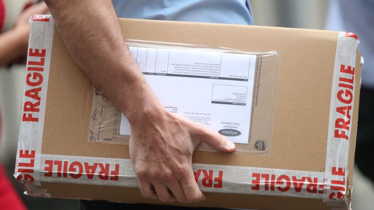 A package containing a digital countdown clock is carried in to 10 Downing Street in London.