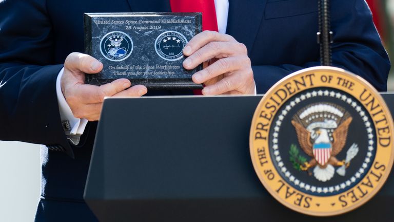 The president shows off a commemorative plaque