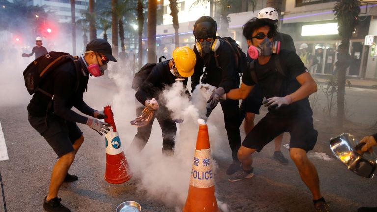 Protesters try to extinguish tear gas canisters in Wan Chai neighbourhood on Sunday