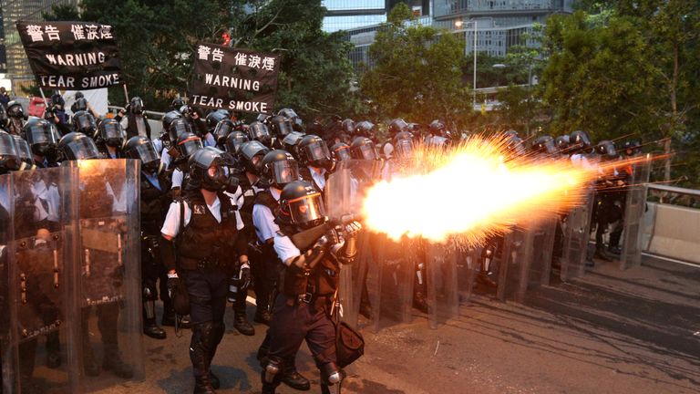 Police officers fire tear gas during a demonstration on 12 June