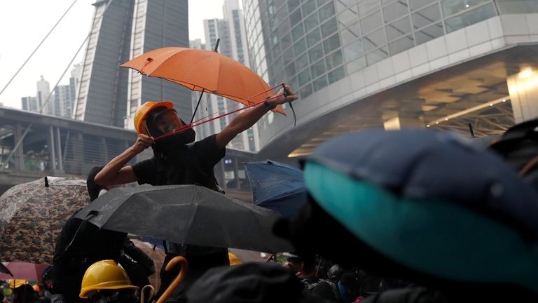 A demonstrator uses a catapult as protesters clash with riot police