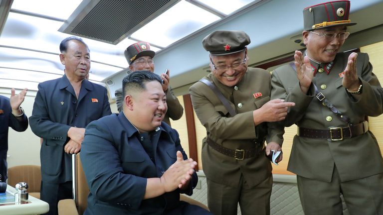 North Korean leader Kim Jong Un reacts to the test firing of a new weapon