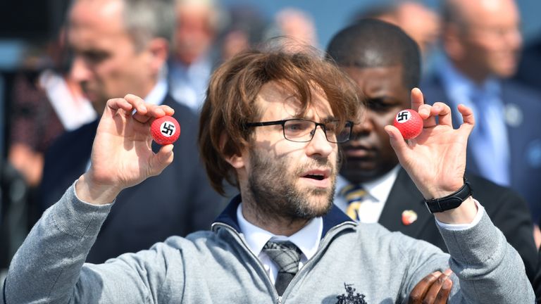 Comedian Lee Nelson/ Simon Brodkin is taken away by security while holding golf balls stamped with swastika as he protests against Donald Trump at his Trump Turnberry Resort in June 2016 in Ayr, Scotland