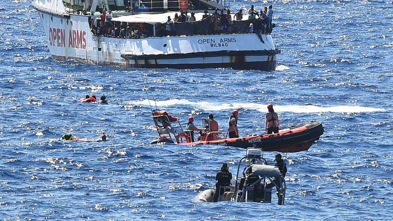 Migrants swim after jumping off the Spanish rescue ship Open Arms, close to the Italian shore in Lampedusa, Italy 