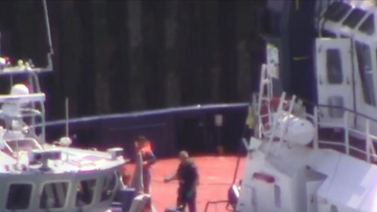 Footage appears to a show a migrant stepping off one boat and onto another off the south coast