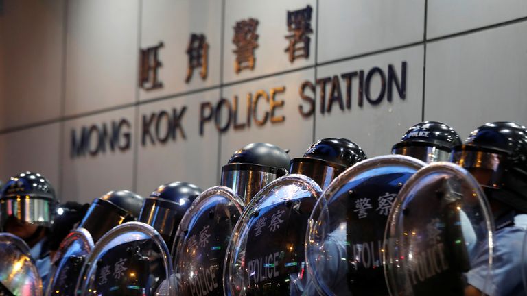 Police officers stand guard outside Mong Kok police station