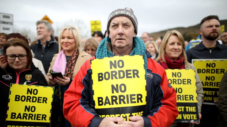 Protesters against any border between Ireland and Northern Ireland because of Brexit hold placards at the Carrickcarnan border between Newry in Norther Ireland and Dundalk in the Irish Republic on March 30, 2019. - British Prime Minister Theresa May on Saturday mulled a possible fourth attempt to get her Brexit agreement through parliament, faced with the growing risk of a chaotic no-deal exit in less than two weeks&#39; time. 