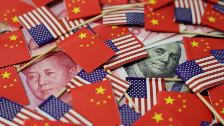 A U.S. dollar banknote featuring American founding father Benjamin Franklin and a China&#39;s yuan banknote featuring late Chinese chairman Mao Zedong are seen among U.S. and Chinese flags in this illustration picture taken May 20, 2019