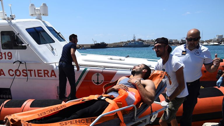 A migrant who jumped off of Open Arms is carried on stretcher in Lampedusa