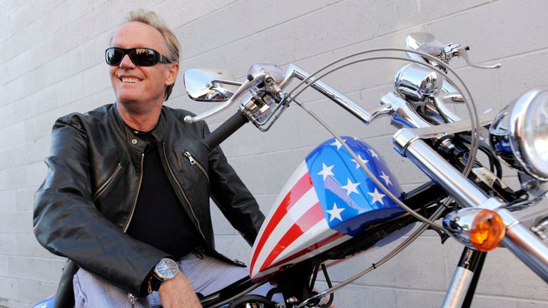 Peter Fonda, poses atop a Harley-Davidson motorcycle in Glendale