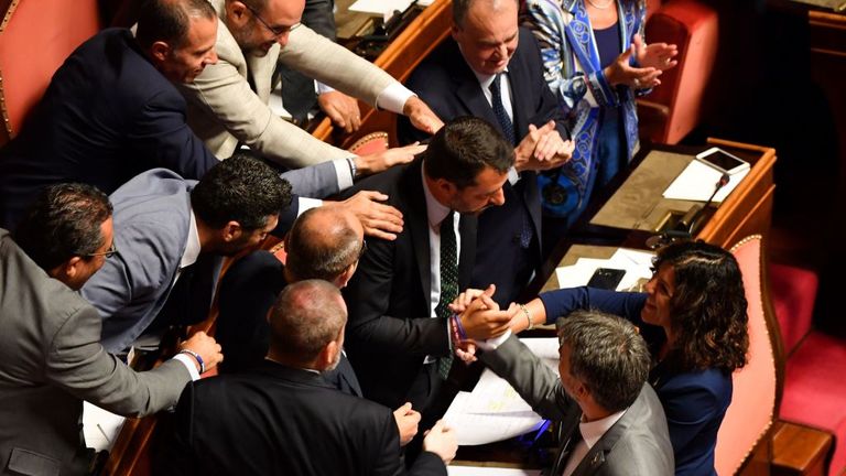 Members of the far-right League party congratulates Deputy Prime Minister and Interior Minister Matteo Salvini (C) following his speech at the Italian Senate, in Rome, on August 20, 2019