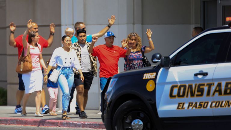 Shoppers exit with their hands up after a mass shooting at a Walmart in El Paso