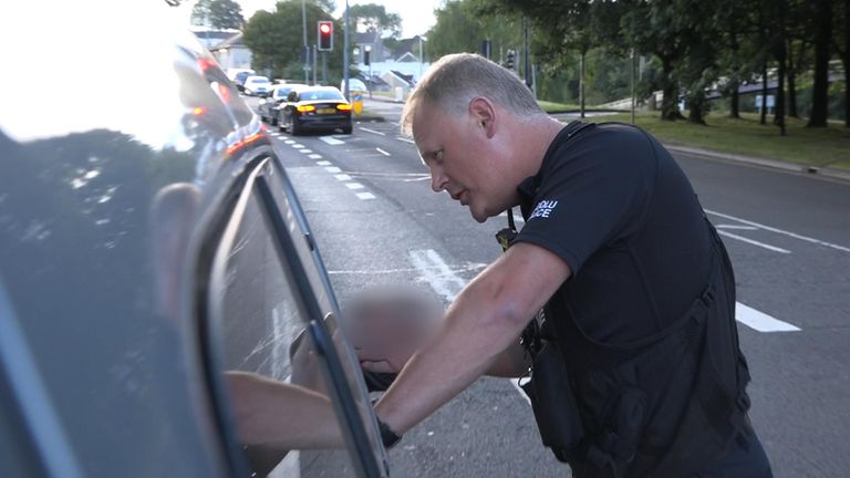 A police officer stops to talk to a suspected kerb crawler in Swansea