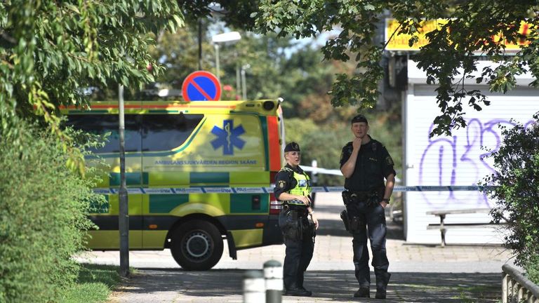 Officers stand near the scene of the shooting on Monday