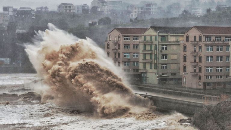 Waves hit a sea wall in front of buildings in Taizhou, China&#39;s eastern Zhejiang province