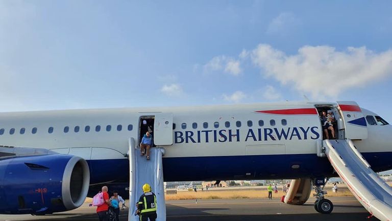 Passengers use emergency slides to leave the smoke filled cabin. Pic: Twitter/@lucyaabrown