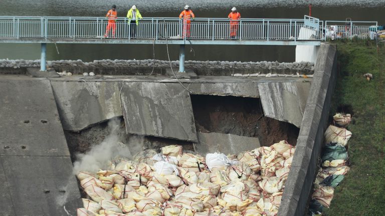 A bag of concrete is thrown onto the damaged Toddbrook Reservoir 
