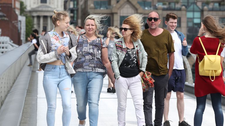 People cross a windy Millennium bridge in London