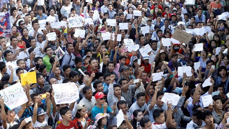 Protesters hold posters and shout as they protest in support of Zaw Lin and Win Zaw Htun