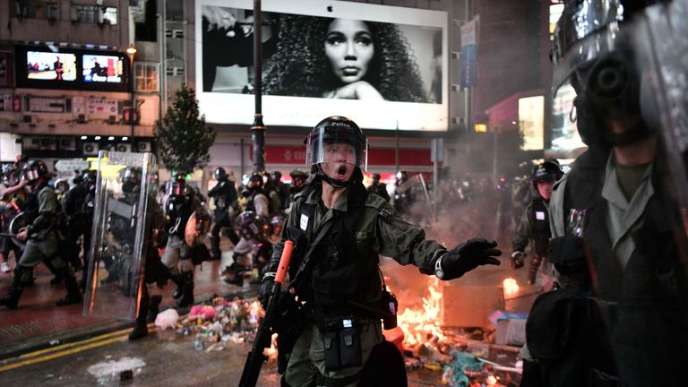 TOPSHOT - Police run past debris set alight by protesters in the Causeway Bay area of Hong Kong on August 31, 2019, as people demonstrate, defying a ban on rallying -- and mounting threats from China -- to take to the streets for a 13th straight weekend. (Photo by Anthony WALLACE / AFP)        (Photo credit should read ANTHONY WALLACE/AFP/Getty Images)