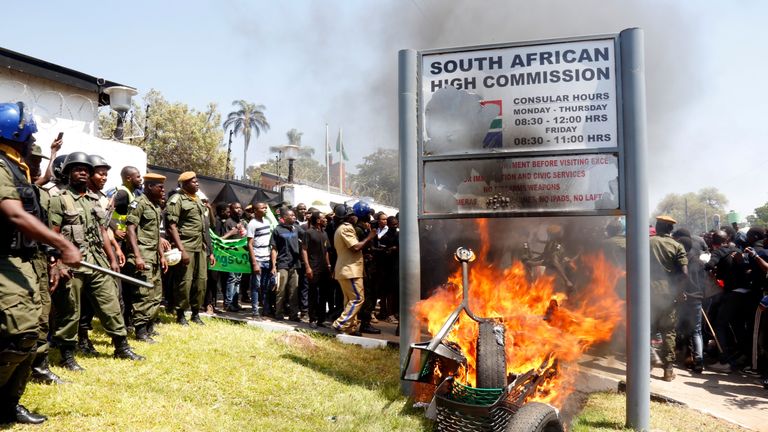 Zambia's unniversity students burn the sign outside the South African Embassy in Lusaka on September 4, 2019 during a demonstration to protest against xenophobic attacks on foreign nationals in the Rainbow Nation. (Photo by SALIM DAWOOD / AFP)        (Photo credit should read SALIM DAWOOD/AFP/Getty Images)