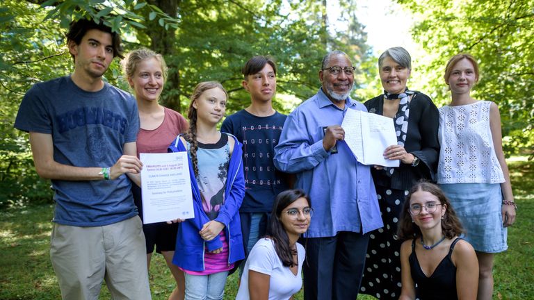 Youth climate activists including Greta Thunberg (3rd L), pose with Intergovernmental Panel on Climate Change (IPCC) vice-chairman Youba Sokona (4thR) and IPCC working group II co-chairman Debra Roberts (3rd R) after the press presentation of a special IPCC report on climate change and land on August 8, 2019 in Geneva. - Humanity faces increasingly painful trade-offs between food security and rising temperatures within decades unless it curbs emissions and stops unsustainable farming and deforestation, a landmark climate assessment said the IPCC. Negotiators from 195 countries on August 8, 2019 finalised the most comprehensive scientific assessment yet of how the land we live off affects climate change, after marathon talks in Geneva. (Photo by FABRICE COFFRINI / AFP)        (Photo credit should read FABRICE COFFRINI/AFP/Getty Images)