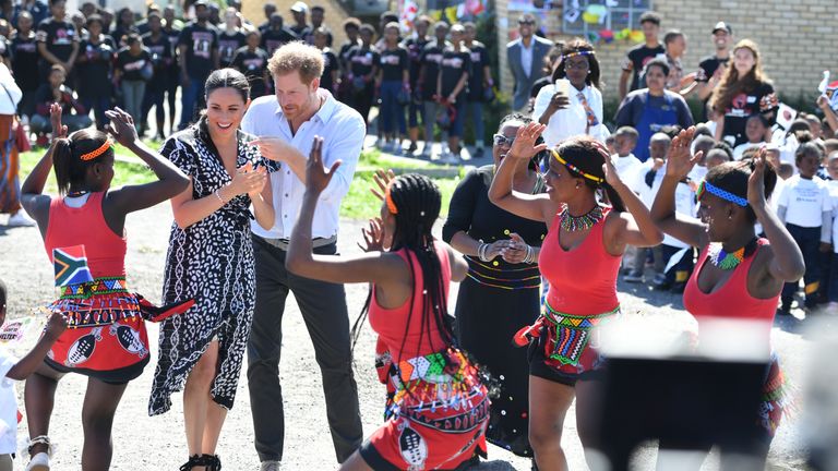 The Duke and Duchess of Sussex watch dancers as they leave the Nyanga Township in Cape Town, South Africa, during the first day of their tour of Africa.