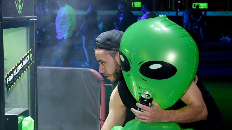 Revellers joke around with an inflatable alien during an Area 51 Celebration in Las Vegas on Thursday