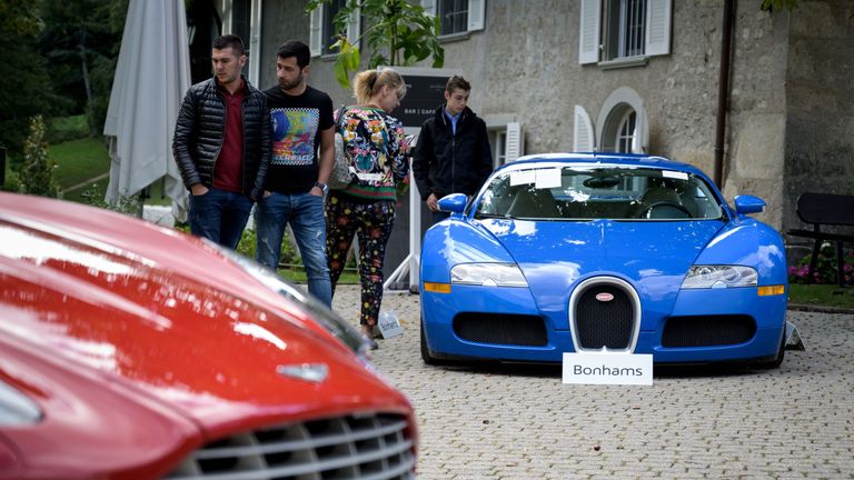 A picture taken on September 28, 2019 at the Bonmont Abbey in Cheserex, western Switzerland shows a 2010 Bugatti Veyron EB 16.4 Coupe model car (R) and a 2011 Aston Martin One-77 Coupe model car during an auction preview by sales house Bonhams of sport cars belonging to the son of the Equatorial Guinea&#39;s President