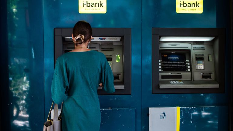 A woman withdraws cash from an ATM machine in Athens on August 26, 2019. - Greek Prime Minister Kyriakos Mitsotakis told parliament on August 26, 2019 that the country would end capital controls imposed four years ago 
