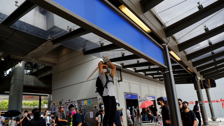 A protester breaks a security camera outside Hong Kong International Airport