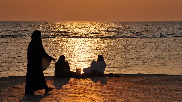 Saudi families spend an evening by a seafront promenade as the sun sets in the Red Sea city of Jeddah