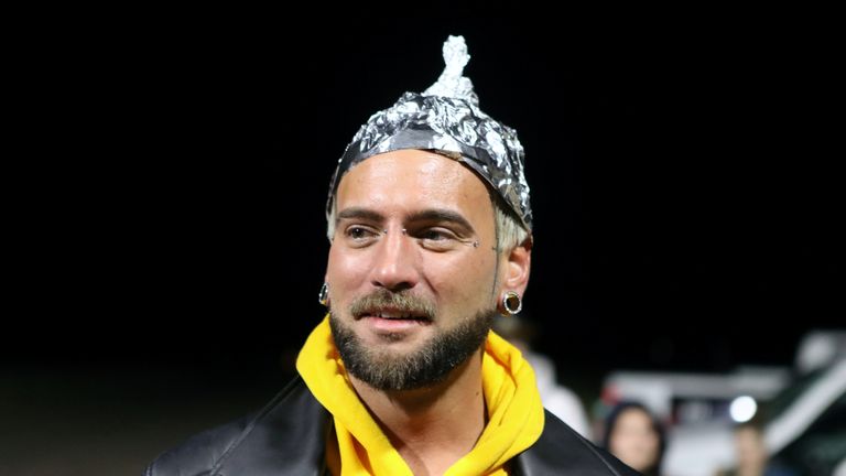An attendee wears a tinfoil hat at the gates of Area 51 