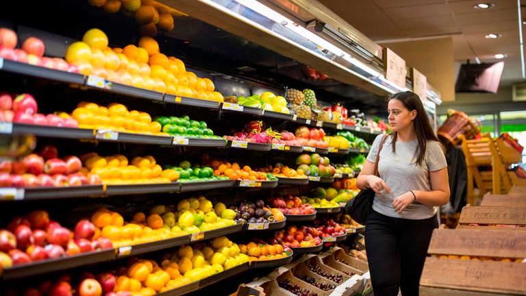 People browse the shelves with loose un-packaged fruit 