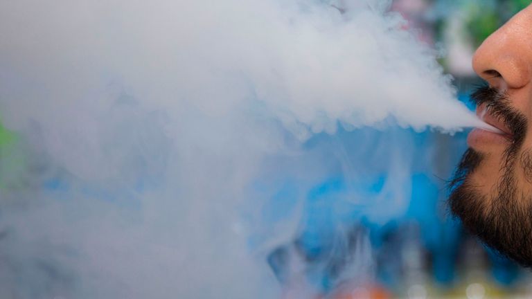 A man smokes an electronic cigarette inside a vape shop in Washington, DC, on July 9, 2019