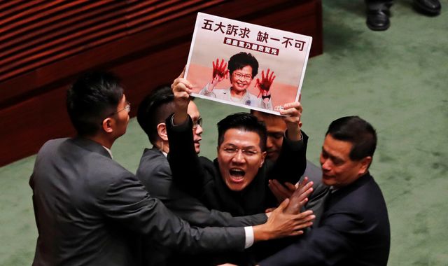 HK politicians dragged out of parliament after activist attacked