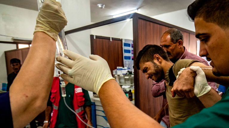 People who were injured during the ongoing Turkish offensive against Kurdish-controlled areas of northeastern Syria receive treatment at a hospital in Tal Tamr, near the Syrian Kurdish town of Ras al-Ain, October 18, 2019. - Sporadic clashes between Turkish forces and Kurdish groups were ongoing in a battleground Syrian border town on October 18, a monitor said, despite Ankara's announcement of a five-day truce. "There are sporadic artillery strikes and you can hear shooting in the town of Ras al-Ain," said Rami Abdul Rahman, head of the Syrian Observatory for Human Rights. (Photo by Delil SOULEIMAN / AFP) (Photo by DELIL SOULEIMAN/AFP via Getty Images)