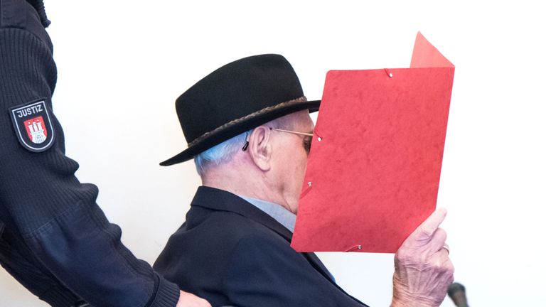 93-year-old former SS guard Bruno Dey covers his face as he arrives in the courtroom in Hamburg, on October 17, 2019. - Dey stands accused of involvement in the murder of 5,230 people when he worked at the Stutthof camp near what was then Danzig, now Gdansk in Poland. (Photo by Daniel Bockwoldt / POOL / AFP) (Photo by DANIEL BOCKWOLDT/POOL/AFP via Getty Images)